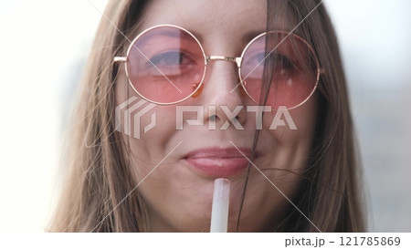 Pensive happy woman sipping a milkshake in the street Pensive happy woman sipping a milkshake in the street 121785869