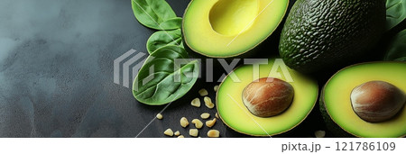 Fresh avocados, spinach leaves and seeds lying on dark background. Avocado background with copy space 121786109