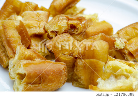 Close up of cut cakoi or youtiao cake on white plate. Close up of cut cakoi or youtiao cake on white plate. 121786399
