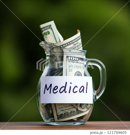 Saving money for medical expenses in a glass jar 121789605