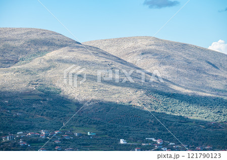 Soft glowing hills with rocks and green vegetation in Berat, Albania Soft glowing hills with rocks and green vegetation in Berat, Albania 121790123