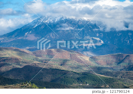 Snow topped mountains and green hills around Berat, Albania 121790124