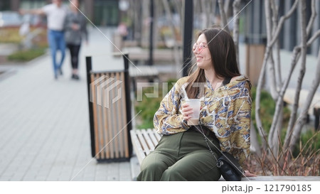 Pensive happy woman sipping a milkshake in the street Pensive happy woman sipping a milkshake in the street 121790185