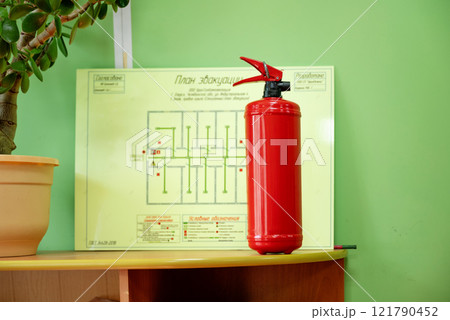 fire extinguisher in the office against the background of a fire evacuation plan. 121790452
