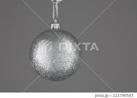 Shiny silver Christmas ball minimalistic on a gray background. Shiny silver Christmas ball minimalistic on a gray background. 121790585