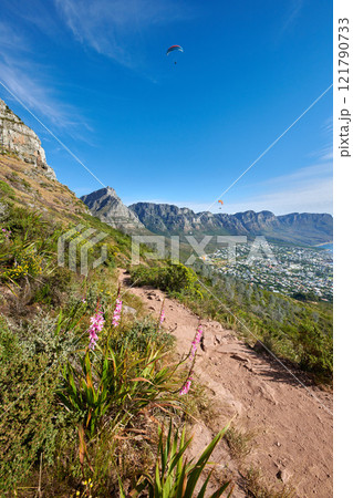 Exploring scenic mountain hiking trail on summer day with active adrenaline activity. Landscape view of path leading to peaceful coastal city on Table Mountain National Park, Cape Town, South Africa. 121790733