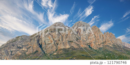 Landscape view of a mountainside with copy space and blue sky background from a lush, green botanical garden or national park. Low angle of rough, rocky, or dangerous terrain in a remote location Landscape view of a mountainside with copy space and blue sky background from a lush, green botanical garden or national park. Low angle of rough, rocky, or dangerous terrain in a remote location 121790746