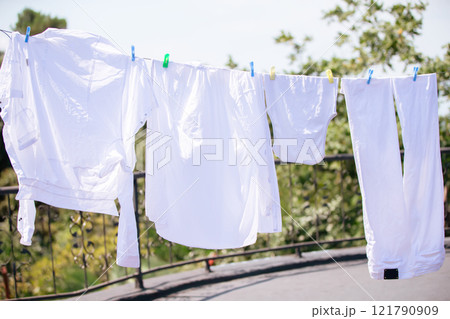 The white clothes are hung up and drying in the wind. 121790909