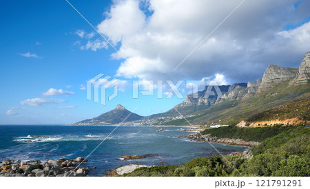 A beautiful sea landscape near a mountain with lush green plants growing outdoors in nature. Peaceful and scenic view of the ocean or beach with copy space on a summer afternoon 121791291