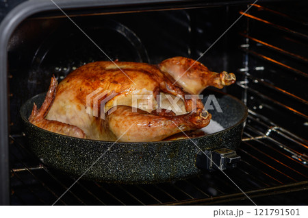 Golden-brown turkey roasting in an oven, filling the kitchen with savory aromas on a festive evening. Golden-brown turkey roasting in an oven, filling the kitchen with savory aromas on a festive evening. 121791501