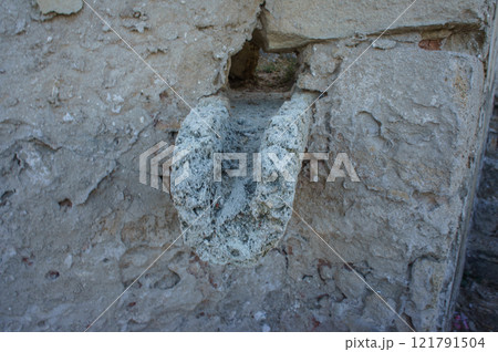 Ancient stone carving in a weathered wall, depicting artistic craftsmanship from a bygone era. Ancient stone carving in a weathered wall, depicting artistic craftsmanship from a bygone era. 121791504