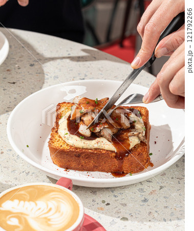Eating brioche breakfast toast with turkey brisket Eating brioche breakfast toast with turkey brisket 121792266