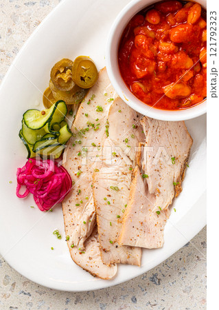 Portion of chicken brisket with beans and pickles Portion of chicken brisket with beans and pickles 121792323