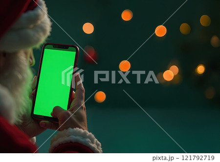 Concentrated santa using smartphone at christmas 121792719