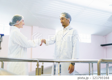 Team of quality control officers or factory engineers are inspecting inside the beverage manufacturing facility. Man and woman engineers working in a food production factory. Team of quality control officers or factory engineers are inspecting inside the beverage manufacturing facility. Man and woman engineers working in a food production factory. 121793168