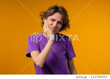 Young pretty woman with tooth pain, yellow background. Toothache, dental problem 121793453
