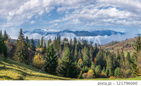 Late autumn mountain morning scene with snow covered tops in far and foggy clouds in valleys. Picturesque traveling, seasonal, nature and countryside beauty concept scene. Carpathians, Ukraine. Late autumn mountain morning scene with snow covered tops in far and foggy clouds in valleys. Picturesque traveling, seasonal, nature and countryside beauty concept scene. Carpathians, Ukraine. 121796000