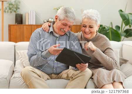 Video call. Happy senior couple woman man with tablet having video call. Mature old grandmother grandfather talking speaking online. Older generation modern tech usage. Virtual meeting online chat 121797368