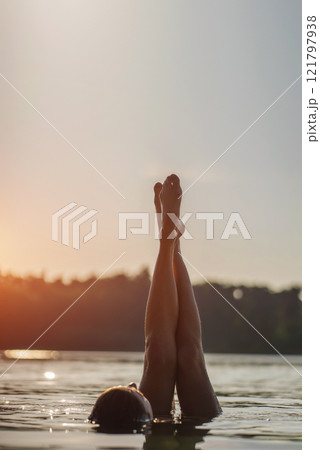 happy tranquil woman have vacation at summer and resting at beach, playing legs with blue water and making splashes, having fun and enjoying sun at nature happy tranquil woman have vacation at summer and resting at beach, playing legs with blue water and making splashes, having fun and enjoying sun at nature 121797938