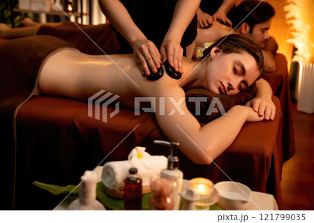 Hot stone massage at spa salon in luxury resort with warm candle light.Quiescent 121799035