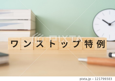 ワンストップ特例の文字が入ったブロックが置かれたデスク 121799383