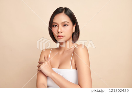 Beautiful young asian woman with clean fresh skin on beige background, Face care, Facial treatment, Cosmetology, beauty and spa, Asian women portrait. Beautiful young asian woman with clean fresh skin on beige background, Face care, Facial treatment, Cosmetology, beauty and spa, Asian women portrait. 121802429