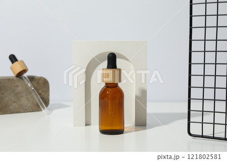 Cosmetic oil in a brown bottle with a decorative bow 121802581