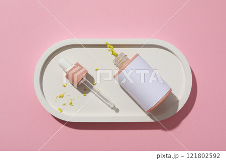 Cosmetic oil in a bottle on a pink background Cosmetic oil in a bottle on a pink background 121802592
