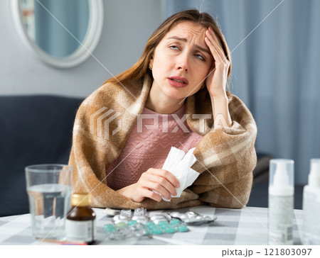 Woman with fever symptoms sitting at home Woman with fever symptoms sitting at home 121803097