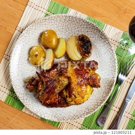 Grilled chicken piece and potatoes served in a plate 121803211