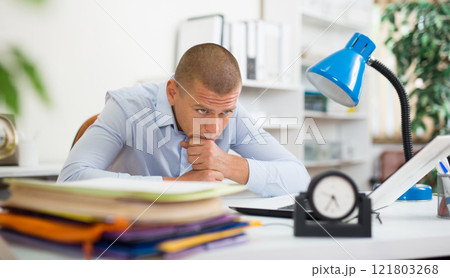 Tired businessman working with documents in office at table 121803268