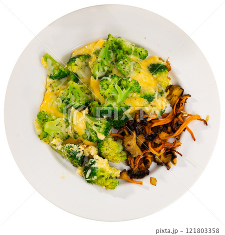 There is stewed broccoli and pickled wild mushrooms chanterelle on plate. 121803358