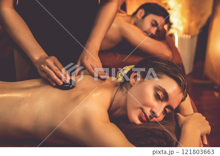 Hot stone massage at spa salon in luxury resort with warm candle light.Quiescent 121803663