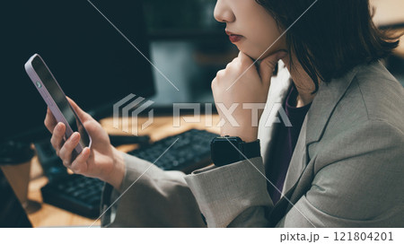 スマホを見て考える女性・ビジネスウーマン スマホを見て考える女性・ビジネスウーマン 121804201