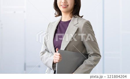 ノートパソコンを持つ笑顔の女性・ビジネスウーマン 121804204