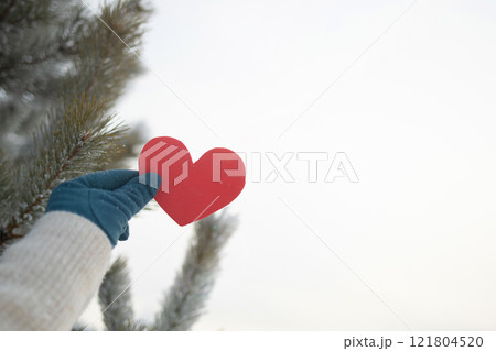 A Heartfelt Winter Gesture Featuring a Red Heart Set Against a Beautiful Snowy Background 121804520