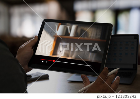 Man watching online videos on Tablet Movie streaming app at home Man watching online videos on Tablet Movie streaming app at home 121805242