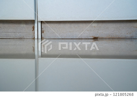 the closet with a white cabinet and a brown stain on the floor 121805268