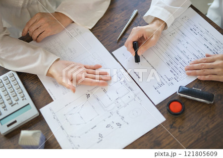不動産の契約を結ぶ女性2人の手元 不動産の契約を結ぶ女性2人の手元 121805609