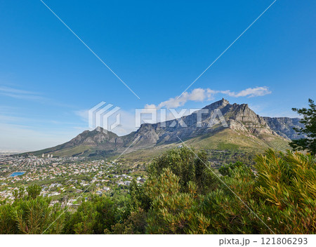 Beautiful view of Table Mountain on a sunny Summer day. Isolate, serene and tranquil view of nature, including blue skies, lush green plants and mountain with steep peak. Region is in South Africa. 121806293