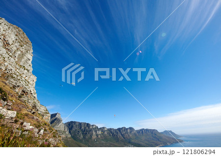 Paragliding across the sky, flying high above the ocean and mountain. For an adrenaline filled summer of fun try an extreme sport with a view of nature. Adventure is for the daring and brave. 121806294