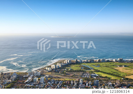 Landscape view of a beautiful coastal city near the beach on a summer day. Aerial view of a popular tourist urban town with greenery and nature during summer. Top view ocean and residential buildings 121806314