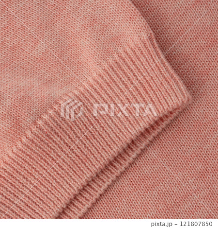 Elastic band close up on the sleeve of a salmon pink knitted cotton polo t-shirt 121807850