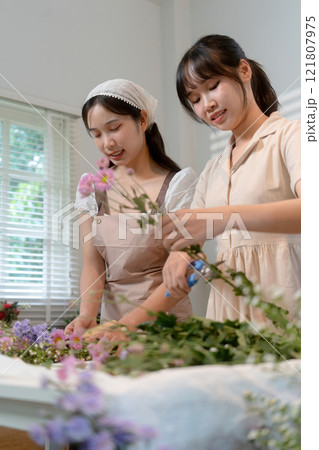Gardeners florist at her own floral shop taking care of flowers. Gardeners florist at her own floral shop taking care of flowers. 121807975