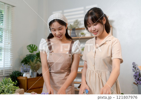 Gardeners florist at her own floral shop taking care of flowers. 121807976