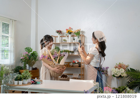 Gardeners florist at her own floral shop taking care of flowers. 121808019