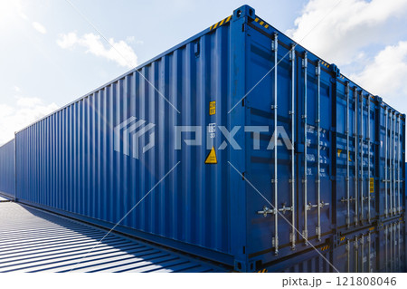 Blue cargo containers are stacked at the storage area in port 121808046