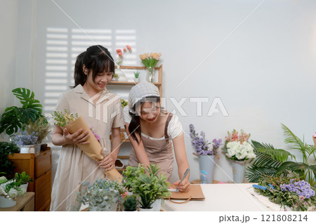 Gardeners florist at her own floral shop taking care of flowers. 121808214
