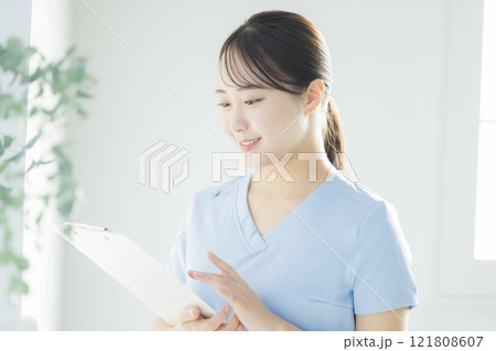 白衣の女性、カルテ、バインダーを持つ、若い女性 121808607