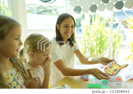 Teacher in workshop teched two girls how to assemble a thermo mosaic  121808641
